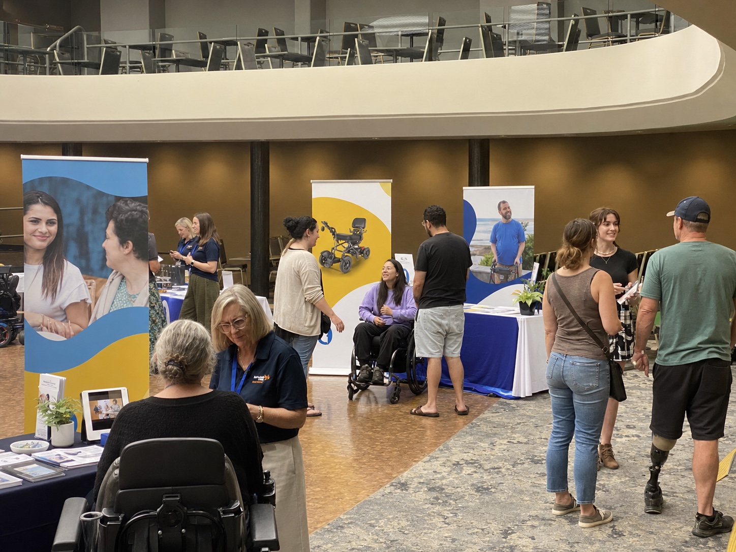 Mixed-age visitors having relaxed conversations with disability service providers